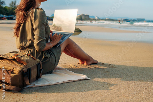woman blogger working remotely with a laptop using the internet. Work on vacation while traveling. Freelance concept photo
