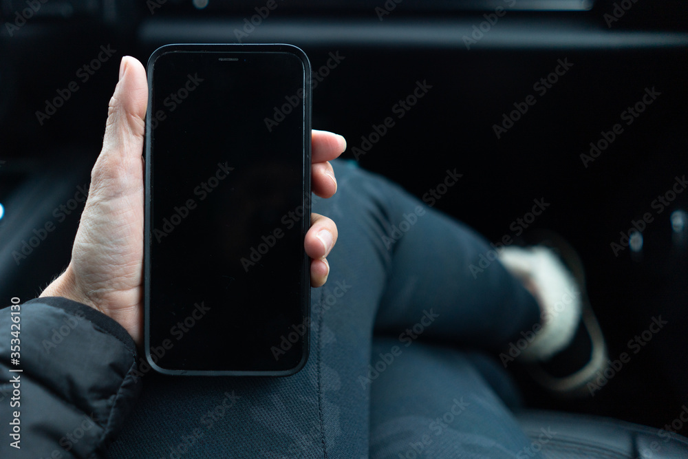 © Sarah Rypma - Overhead view a smart phone in hand inside a car