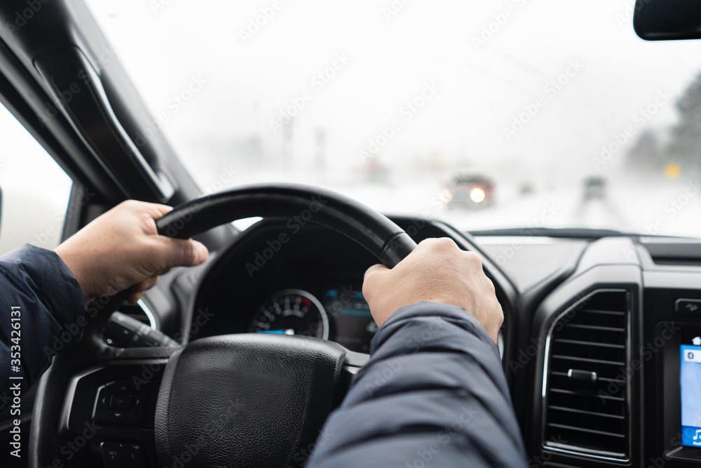 Man's hands on a steering wheel of SUV in winter Man's hands on a steering wheel of SUV in winter