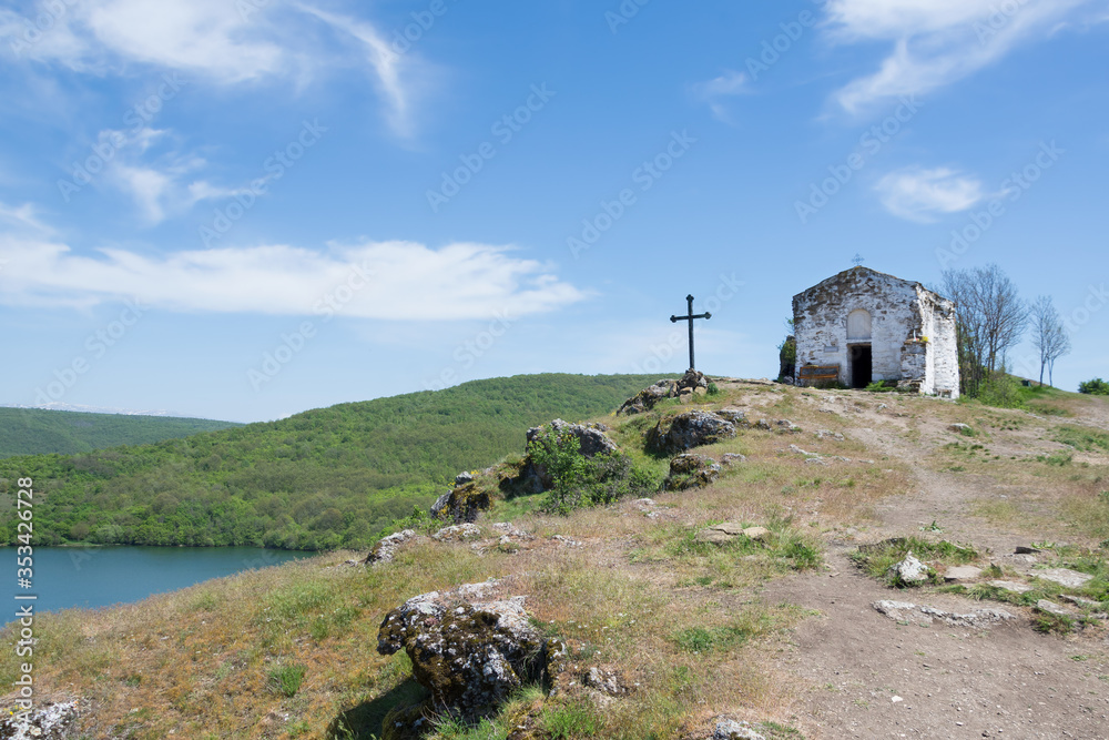 The small Eastern Orthodox church of Saint Ivan Letni from year 1350 perched high on top of rocky hill overlooking Pchelina Lake, Bulgaria The small Eastern Orthodox church of Saint Ivan Letni from year 1350 perched high on top of rocky hill overlooking Pchelina Lake, Bulgaria