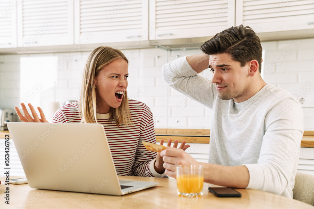 Portrait of couple using laptop and holding credit card while sitting Portrait of couple using laptop and holding credit card while sitting