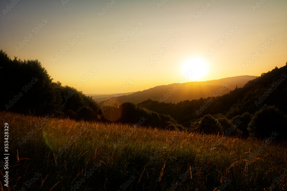 Beautiful sunset over hills and forest. Magic light during golden hour