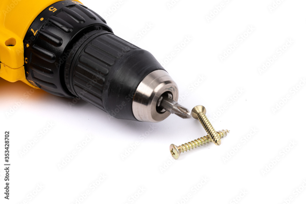 closeup of a yellow battery operated drill with screwdriver bit and phillips wood screws isolated on white closeup of a yellow battery operated drill with screwdriver bit and phillips wood screws isolated on white