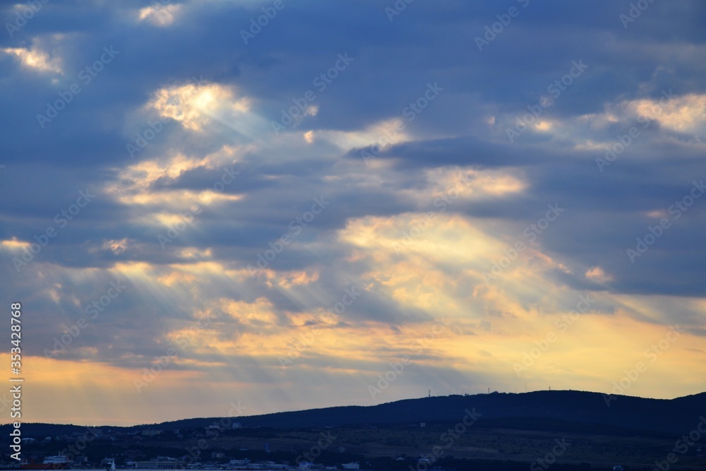 Sunset rays through clouds on coastal cities