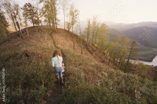 Mother kid and dog hiking and walking in mountains with beautiful valley view