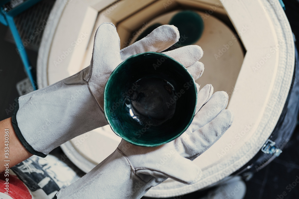 Ταπετσαρία Clay master Hands wearing gloves holding cup from ceramic kiln