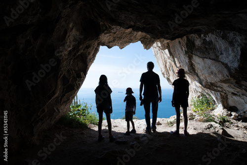 Silhouettes of tourists standing in the entrance of a cave © rocklights