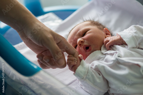 Beautiful newborn baby boy, laying in crib in prenatal hospital
