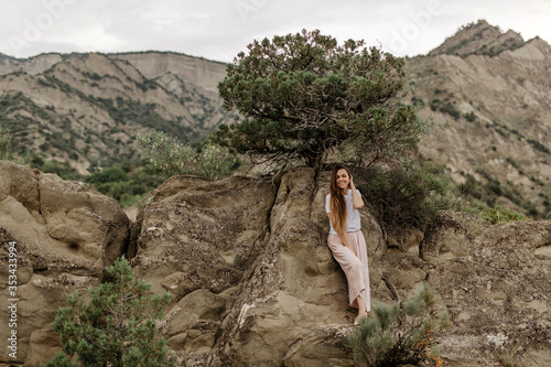 Girl sitting on the rocks in the mountains