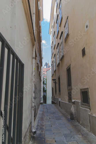 Narrow street in Vienna with urban cityscape view. Historic landmarks from the touristic roads in the capital of Austria. Facade of buildings from the sides. 