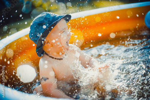 Little boy having fun and splashes water in orange pool © Kaspars