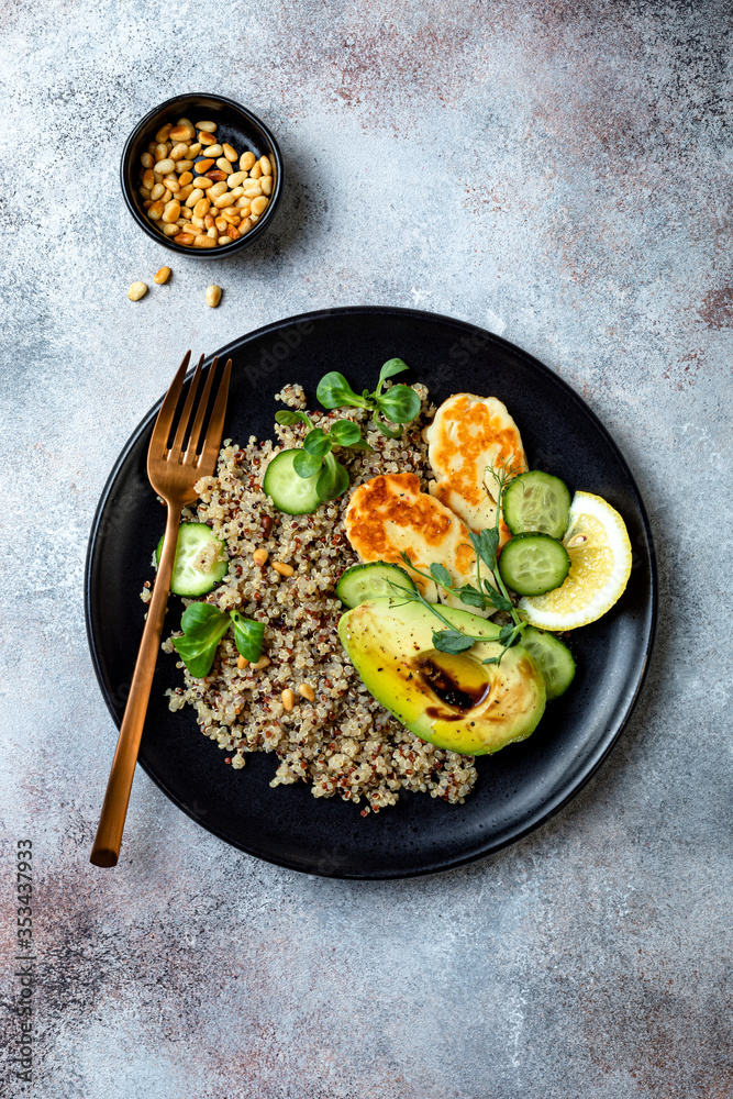 Grilled Halloumi cheese salad with quinoa, avocado, cucumber, toasted pine nuts dressed with honey balsamic vinaigrette. Healthy vegetarian dinner