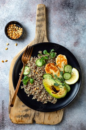 Grilled Halloumi cheese salad with quinoa, avocado, cucumber, toasted pine nuts dressed with honey balsamic vinaigrette. Healthy vegetarian dinner