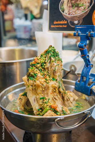 Laeng saeb dish (pork bones and green chilies) one of the most popular Thai street foods at Talad Rot Fai Train Night Market Ratchada in Bangkok, Thailand photo