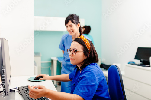 Two nurses using a computer in a x-ray room