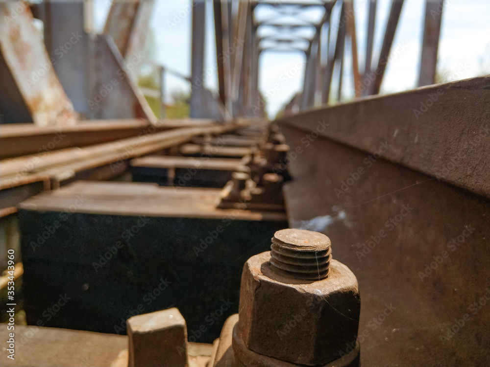 A rusted railroad bridge on a sunny day with cloudy blue sky on the background. A rusted railroad bridge on a sunny day with cloudy blue sky on the background.