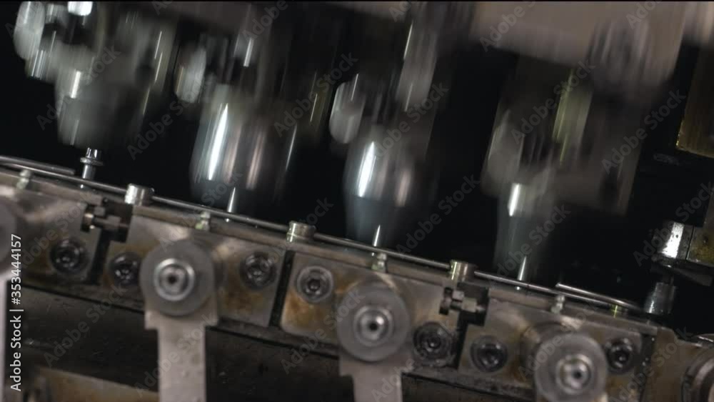 Close-up view of automated industrial equipment making special screws for automotive industry. Machinery working on components for hi tech engines. Robotics and automation. WITH ORIGINAL SOUND