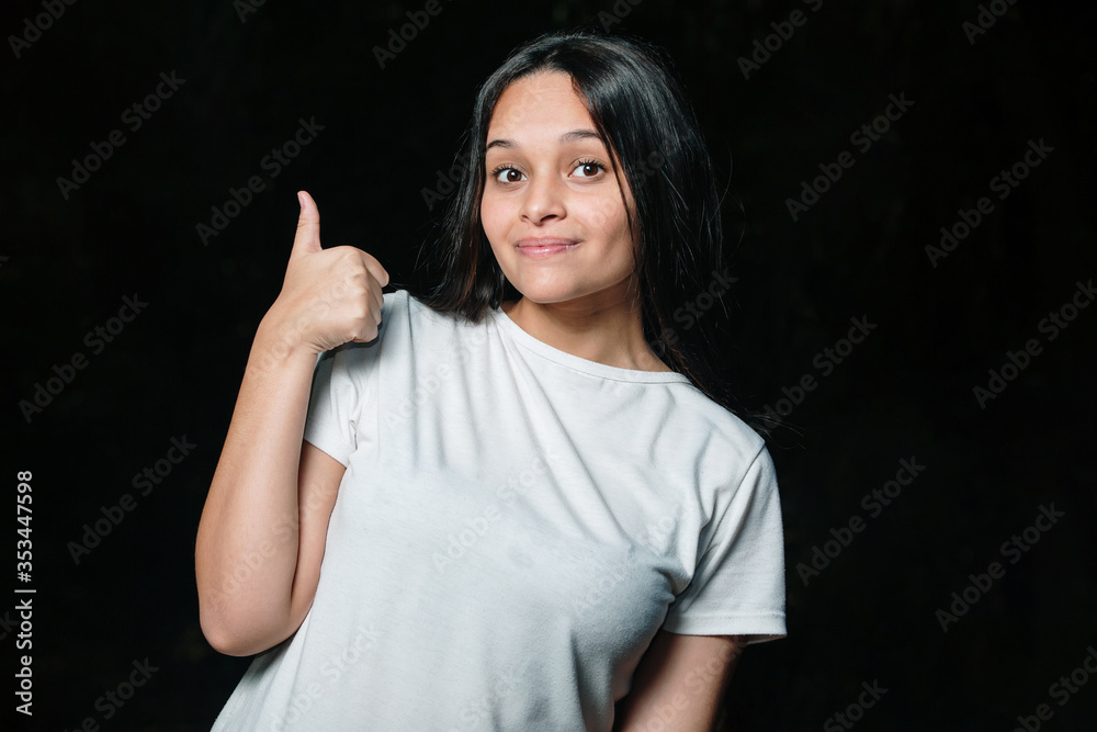 Beautiful brunette teen girl smiling showing thumbs up. Beautiful brunette teen girl smiling showing thumbs up.