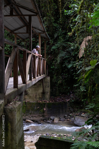 Man over a wooden bridge at Podocarpus National Park, Ecuador photo