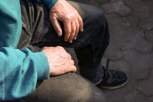 Hands of an elderly man on his knees. crop