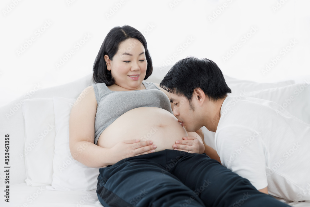 husband kissed pregnant wife on white bedroom husband kissed pregnant wife on white bedroom