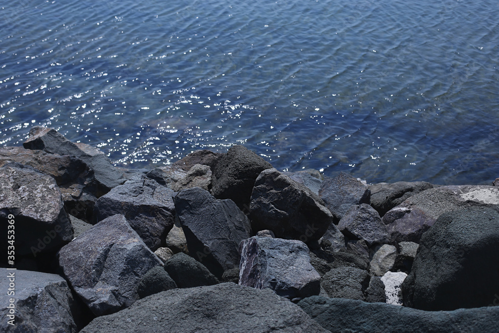 Grey granite sea rocks in Black sea .Ripples on blue water surface. Grey granite sea rocks in Black sea .Ripples on blue water surface.