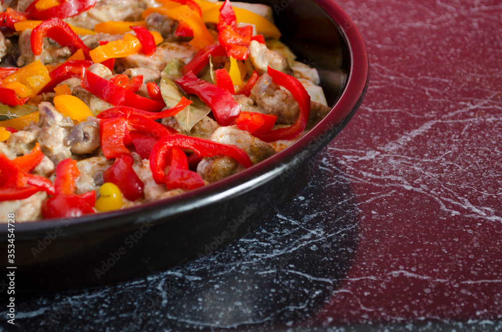 Meat casserole with vegetables close-up. Cooking process. Homemade side dish in the oven pan with copy space.