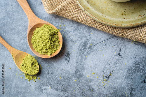 Green tea matcha powder on a  wooden spoon.