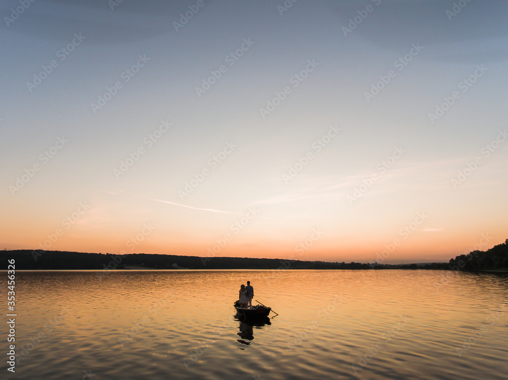 Couple in a boat on the lake. Looking to the other shore.