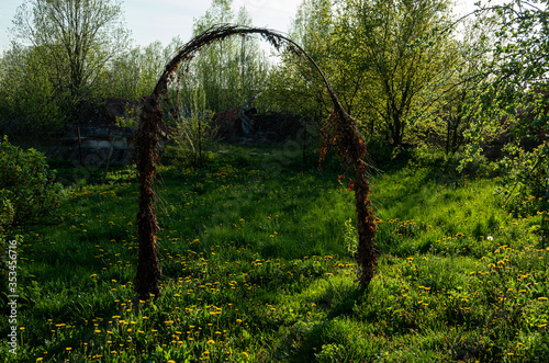 Old festival tree branch gate in dandelion meadow