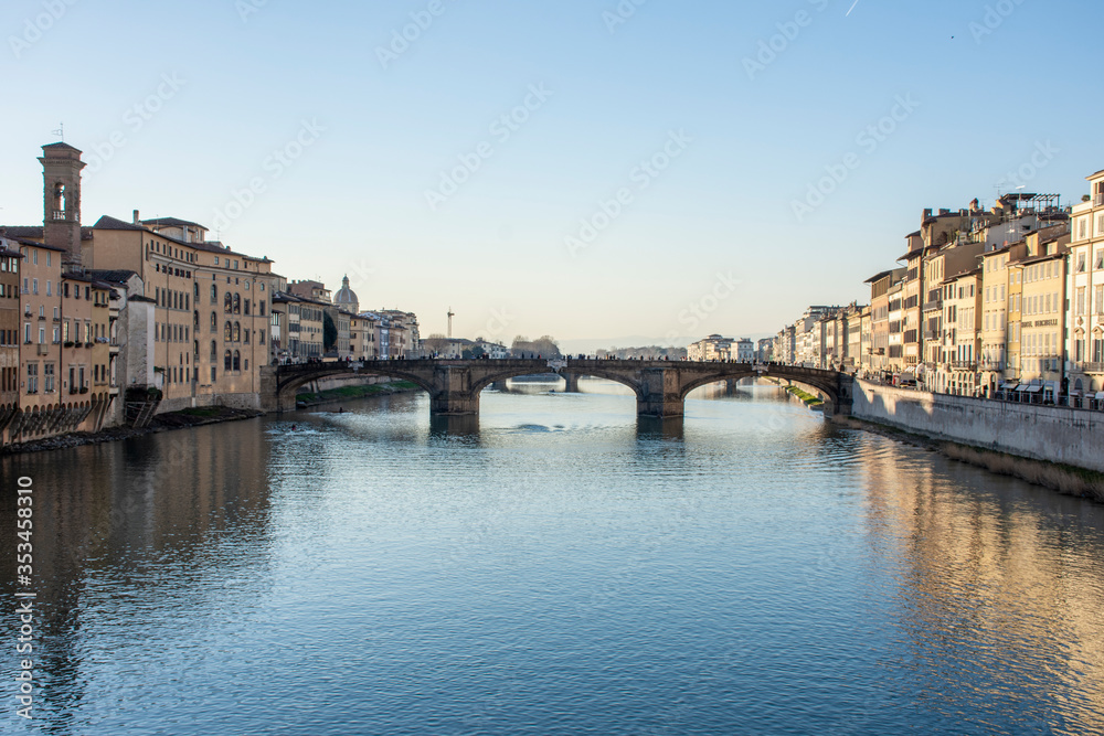 Puente atravesando río en ciudad de Florenica con día soleado