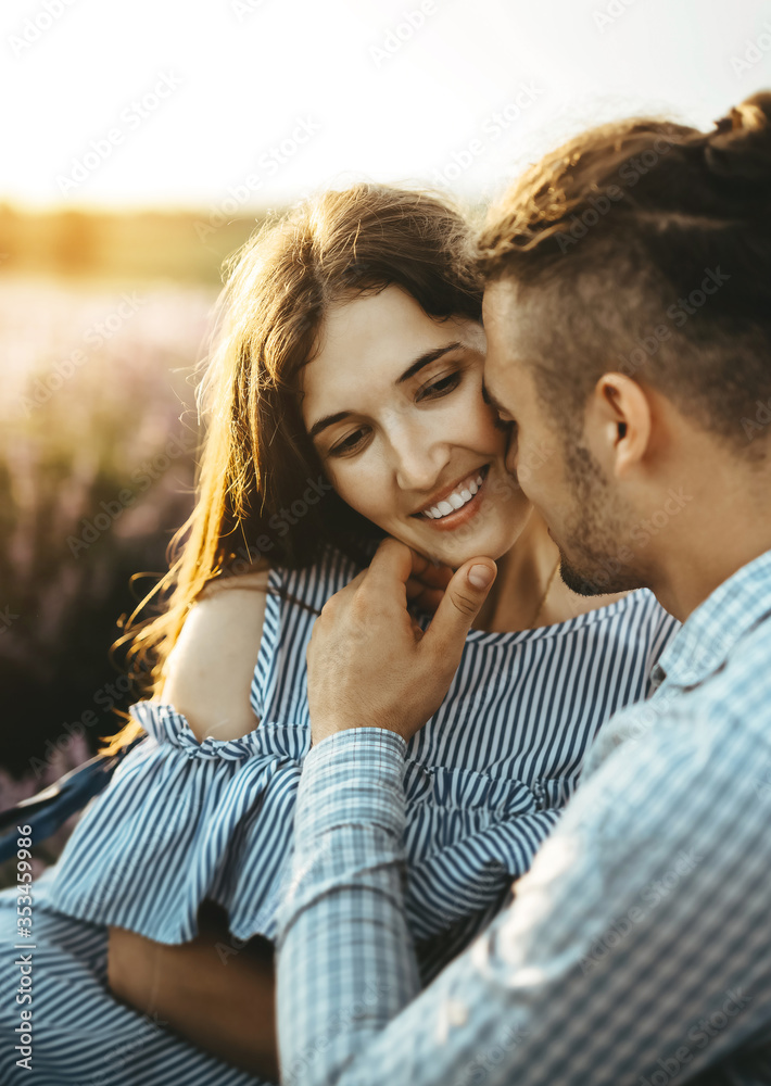 Beautiful young couple dating and walking together outdoor in lavender field. Beautiful young couple dating and walking together outdoor in lavender field.