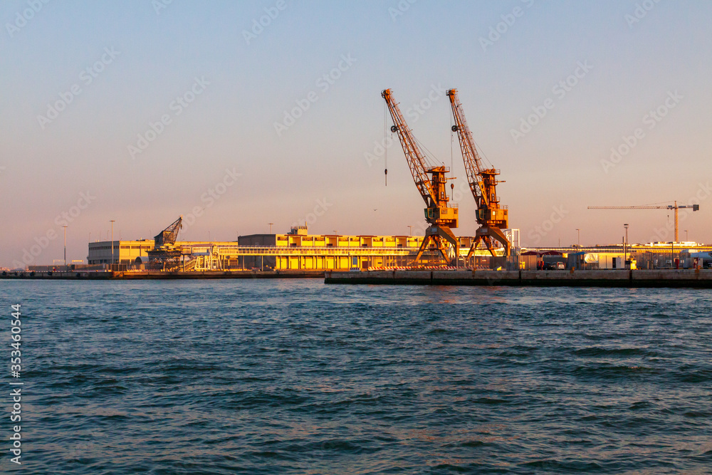 Two large port cranes in evening light