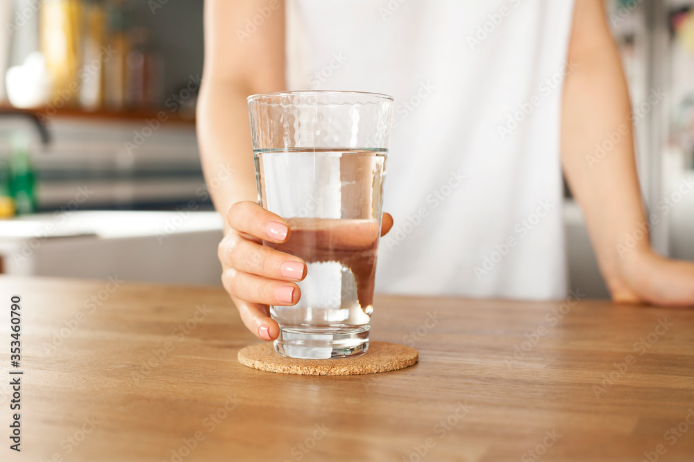 Young woman holds a glass of water. clean drinking water in a clear glass in your hands close-up. Young woman holds a glass of water. clean drinking water in a clear glass in your hands close-up.