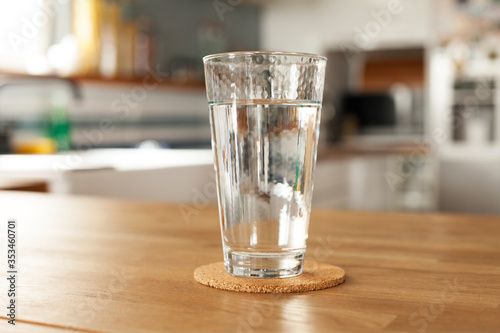 Glass of pure water and bottle on kitchen table