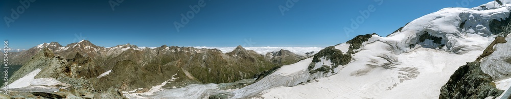Panoramic view on Swiss Alps and Fee glacier as seen from Mittelallalin above the Saas-Fee