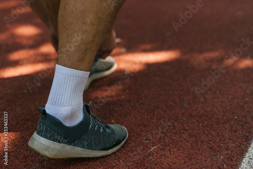 Close-up photo of male running shoes on a race track in the park © qunica.com