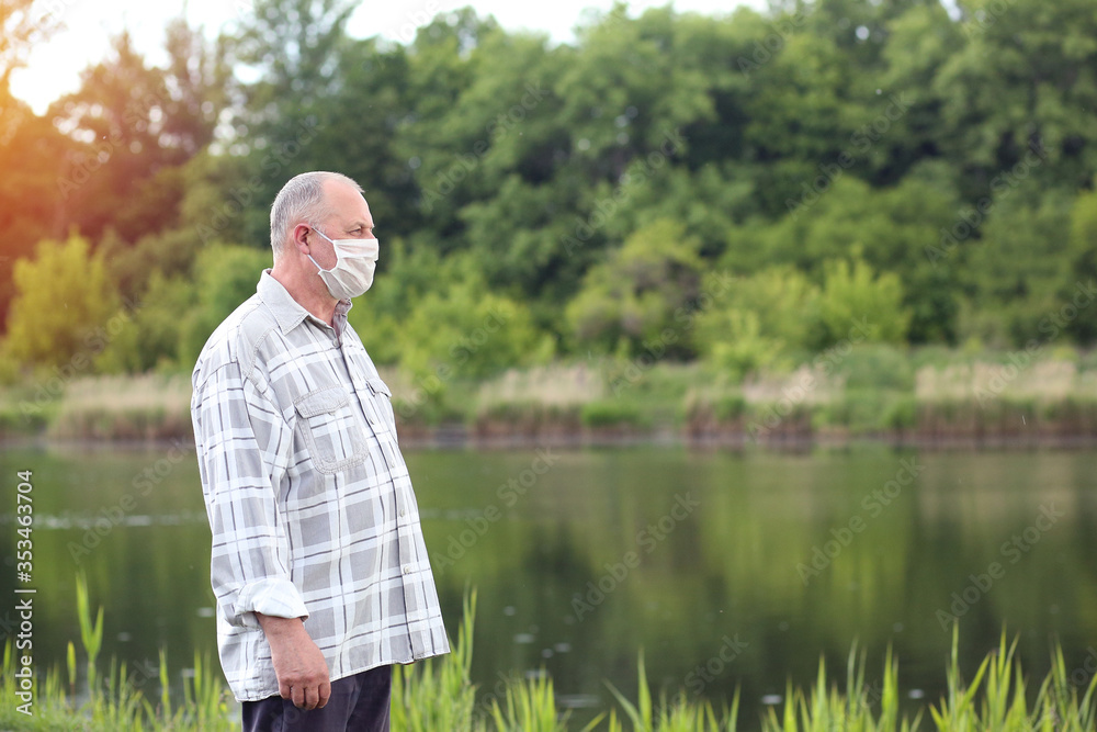 Elderly lifestyle. Mature man in protective mask preventing an epidemic. A man over 60 years old looking into the distance. Copy space on the right. Concept COVID-19. Elderly lifestyle. Mature man in protective mask preventing an epidemic. A man over 60 years old looking into the distance. Copy space on the right. Concept COVID-19.