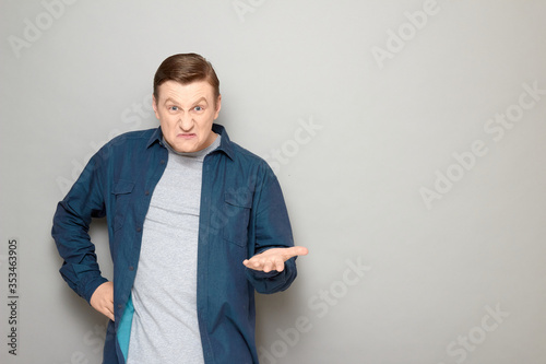 Portrait of furious man raising hand and making demands or rebuking