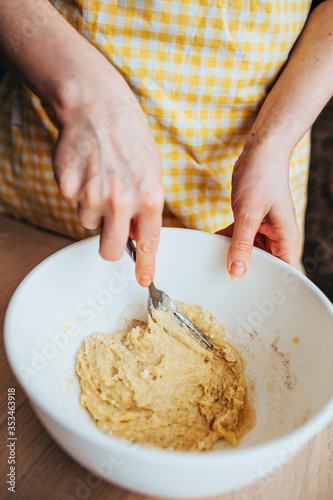 Thick viscous dough in a bowl - woman bakes a sweet apple pie