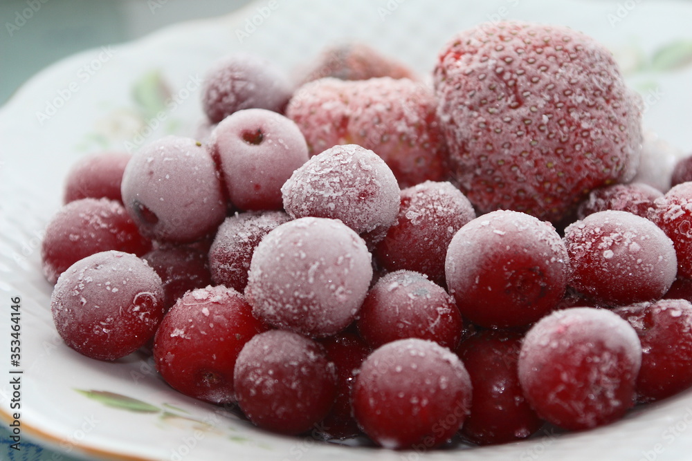 Frozen cherries and strawberries on a white plate Frozen cherries and strawberries on a white plate