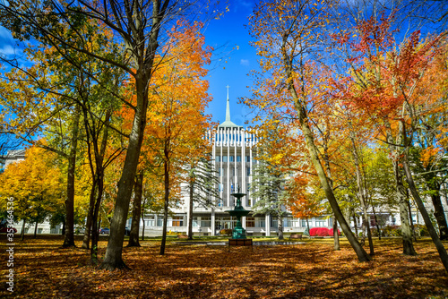 Facade of the Seminary of Saint-Hyacinthe through colorful trees in autumn