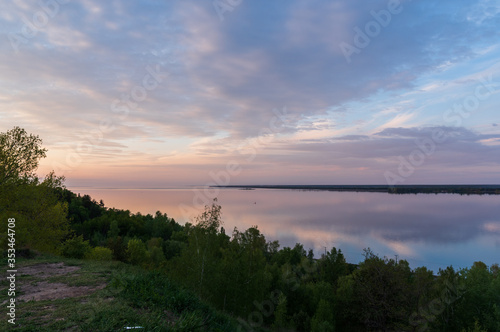 Evening landscape by the sea. Beautiful sunset over a large lake. Beautiful sky and reflection in the water. Evening by the lake.