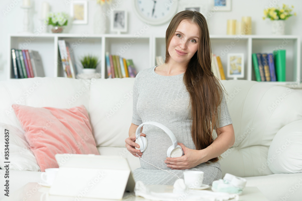 Happy pregnant woman with headphones on belly Happy pregnant woman with headphones on belly