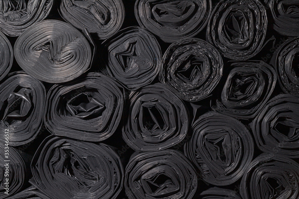 Rolls of plastic bags. Textured background for wallpaper. Lots of black rolled up bags for construction waste.