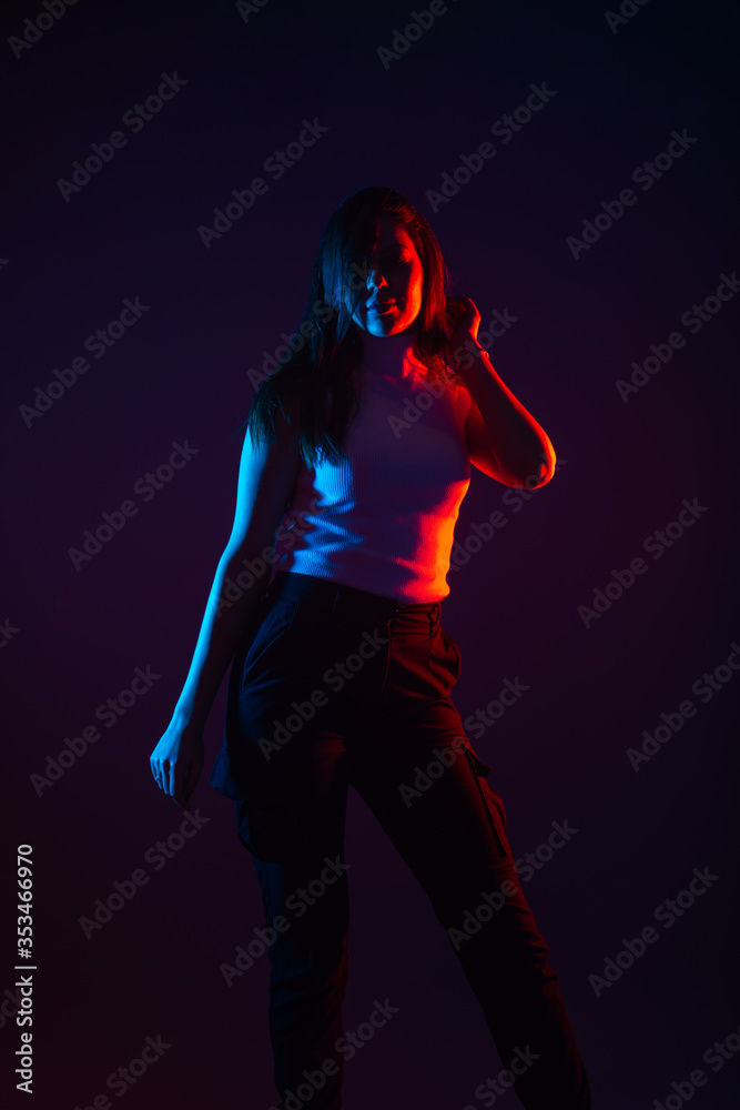 Blue and red light portrait of a female model on a black background with high contrast