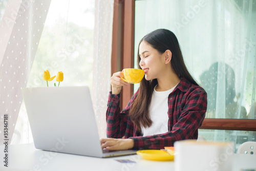 Beautiful woman is working with laptop computer in coffee shop