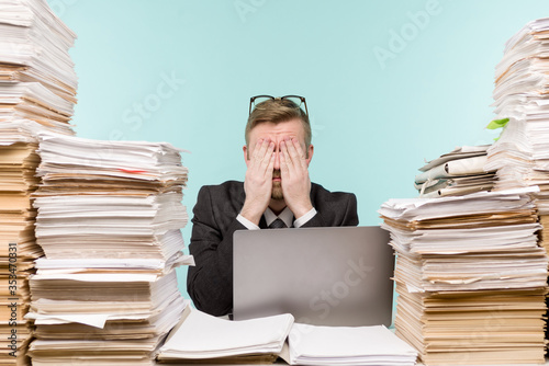 Close-up image of a stressful businessman tired from his work on the foreground photo