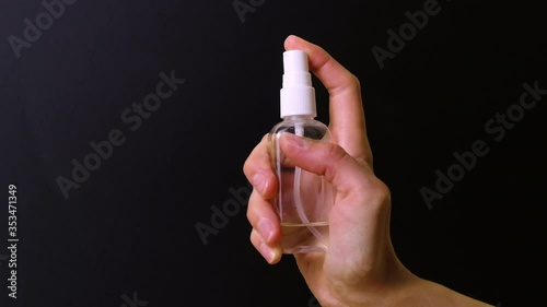 Close up of woman hands spraying disinfectant and clean hands, coronavirus protection. Epidemic prevention, disinfection, bacteria, virus protection. Video with dark background