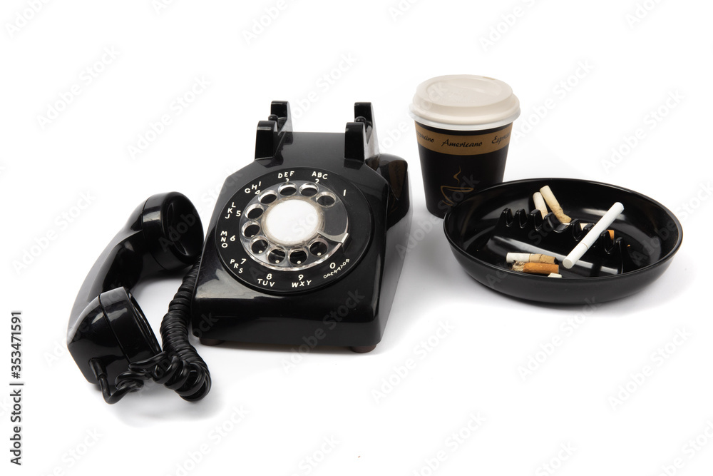 a back rotary telephone, a cup of coffee and an ashtray full of cigarette butts isolated on white
a back rotary telephone, a cup of coffee and an ashtray full of cigarette butts isolated on white